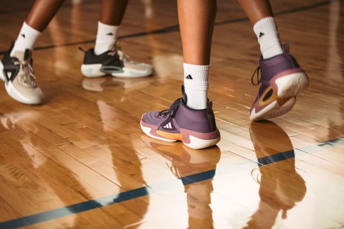 View of purple and orange adidas women's basketball shoes.